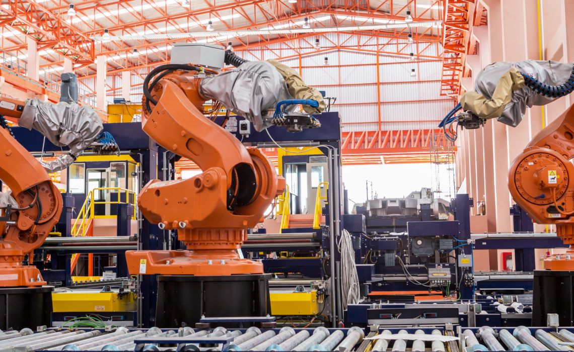 Industrial welding robots in production line manufacturer factory.
