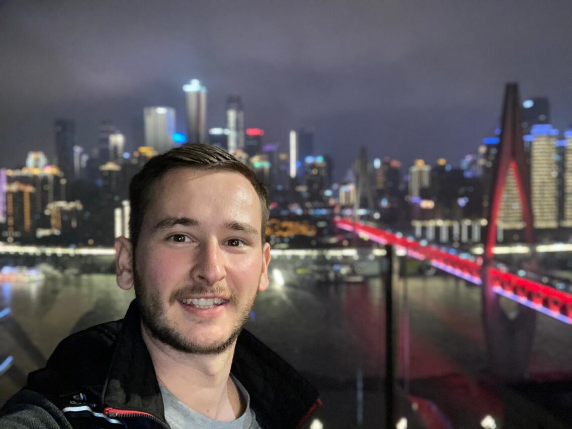 Image of David Schneider in front of a skyline in China