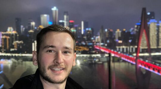 Image of David Schneider in front of a skyline in China