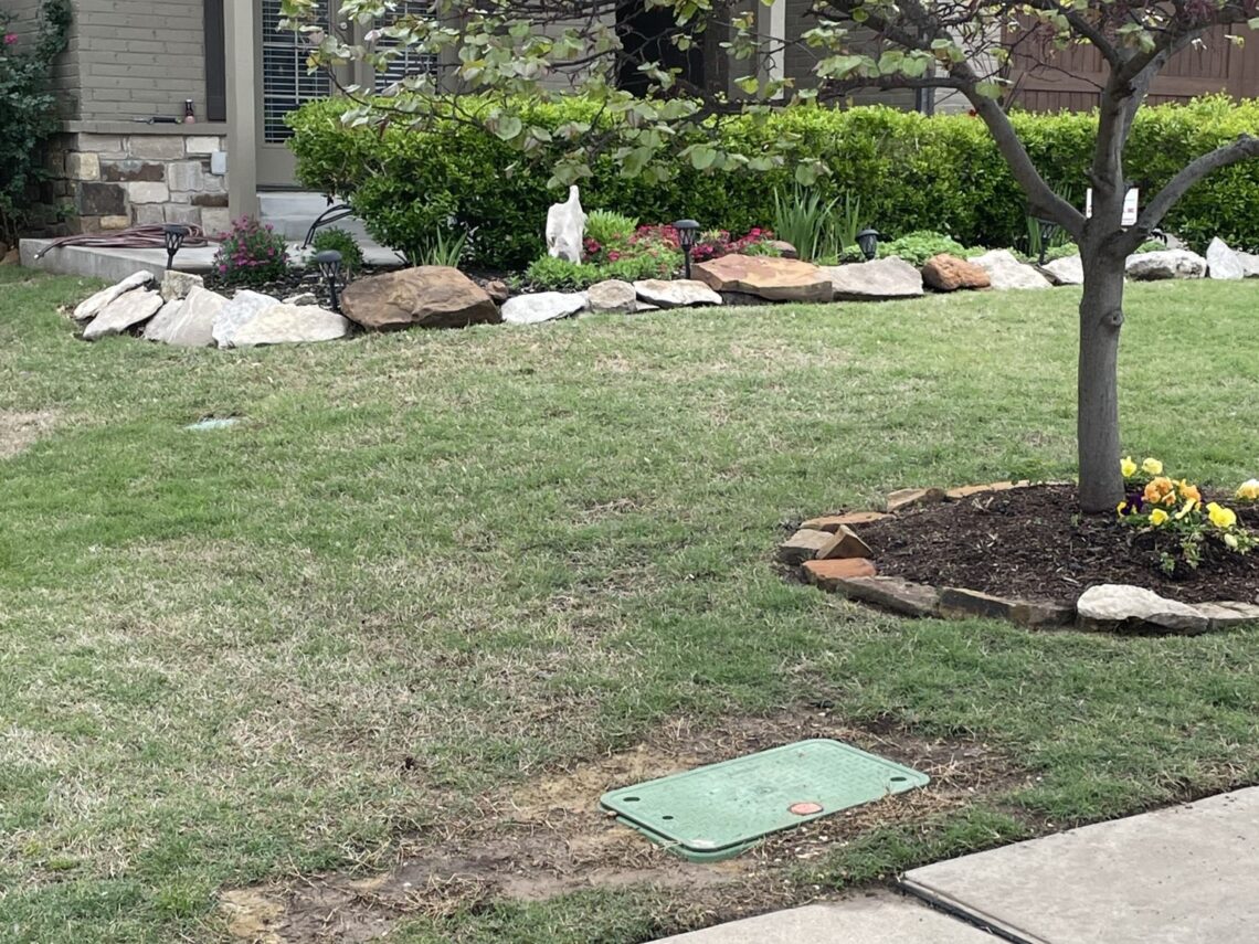 Image of an installed NDS access box for fiber optic cables in a front yard