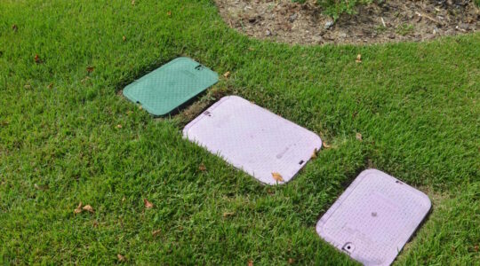 Vorgarten mit NDS Ventilboxen in den Farben Grün und Lila