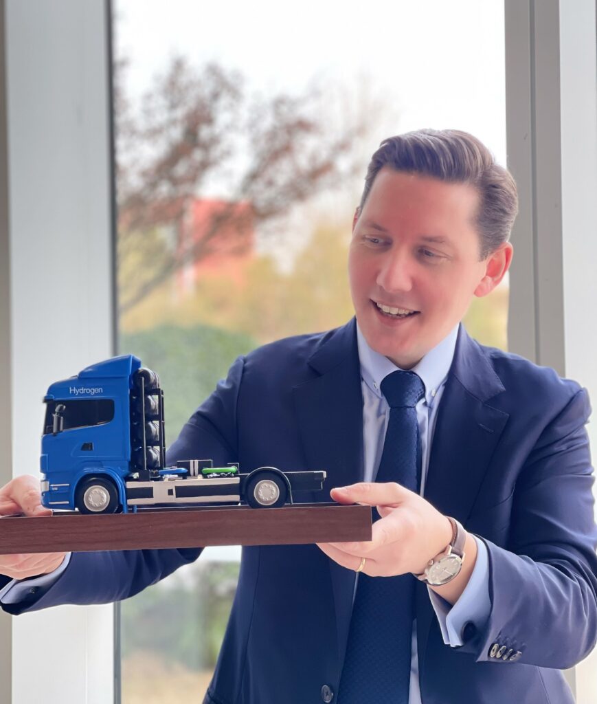 Image of employee of NORMA Group with miniature truck model