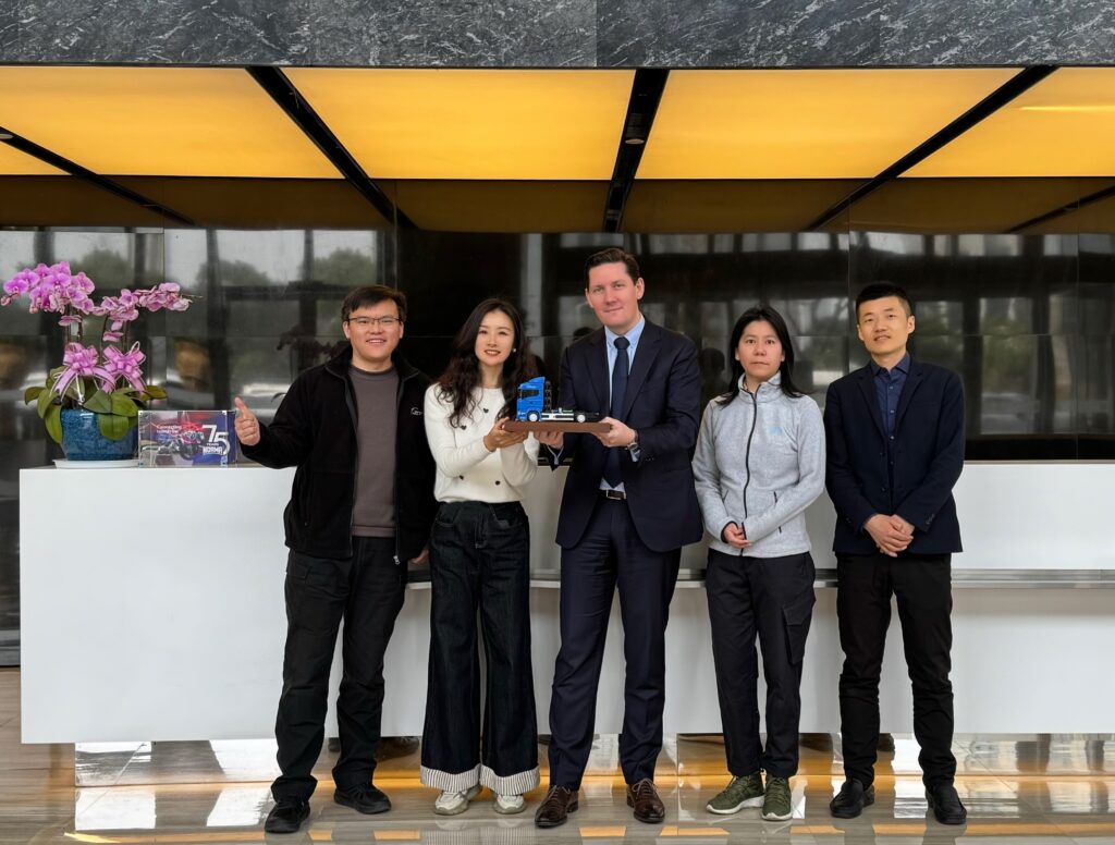 Image of NORMA Group employees with the miniature truck model